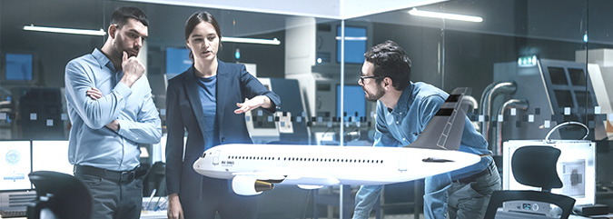 Drei Personen stehen ein einem modernen Besprechungsraum und haben ein virtuelles Flugzeugmodell vor sich